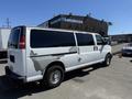 A 2007 Chevrolet Express van with a white exterior featuring noticeable paint wear on the side and tinted windows