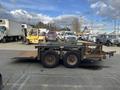 A 2013 JLG Industries Flat Deck Trailer with a flat loading surface and two wheels visible on each side