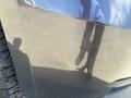 A 2016 Chevrolet Tahoe with visible scratches on its surface and a reflection of a person wearing pants and shoes on the body of the vehicle