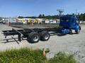 A blue 2008 Peterbilt 340 truck with a flatbed chassis and dual rear wheels parked on a gravel surface