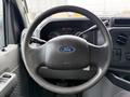 Steering wheel of a 2019 Ford Econoline featuring the Ford logo with dashboard instruments visible behind it