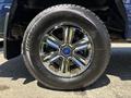 Close-up of a chrome wheel rim on a 2015 Ford F-150 tire showing the Ford logo in the center