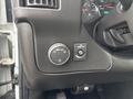 Interior dashboard controls of a 2022 GMC Savana including a headlight dial and a switch for fog lights