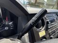 Close-up of the steering wheel controls of a 2014 Ford F-250 SD featuring a multifunction lever with buttons for adjusting settings and a speedometer in the background