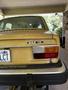 A rear view of a 1978 Volvo 244 with a yellow exterior featuring a damaged area on the trunk and the model designation 244 DL visible on the left side