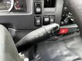 Close-up of the turn signal and wiper control stalk on a 2018 Isuzu NPR dashboard with various buttons and gauges visible in the background