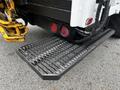 The rear of a 2014 Hino 195 truck featuring red circular lights and a black textured step plate with a wide tread design for better grip