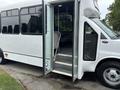 A 2020 Chevrolet Express cutaway bus with an open door and steps leading into the interior