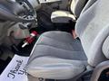 A gray upholstered driver's seat in a 2015 Freightliner M2 106 with a visible passenger seat and fire extinguisher beneath the dashboard