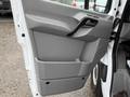 Interior door panel of a 2017 Mercedes-Benz Sprinter featuring a gray design with a handle and a storage compartment
