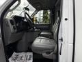 2017 Ford Econoline cab interior featuring two gray seats and a dashboard with various controls and instruments