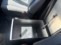A metal storage compartment with a lid located between the front seats of a 2007 Chevrolet Express van
