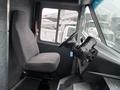 Interior view of a 2012 Ford Econoline featuring a single gray driver's seat and a dashboard with various controls and gauges