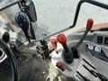Interior view of a 2011 Kubota M8540D tractor showing gear levers and control sticks with red and black handles