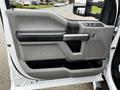 Interior view of the driver's side door of a 2017 Ford F-550 featuring a gray panel with a black armrest and controls for windows and locks