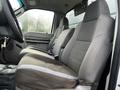 Interior view of a 2009 Ford F-550 showing two gray fabric front seats positioned side by side with seat belts and a simple dashboard design