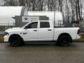 A white 2022 RAM 1500 Classic pickup truck with a double cab and black wheels is parked side view