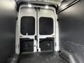 Interior view of the rear doors of a 2020 Ford Transit van showing wide open space with black walls and a flat floor