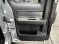 The image shows the interior door panel of a 2014 Ford F-150 featuring a textured black surface with a handle and a control panel for windows