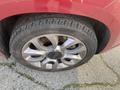 Close-up of a silver alloy wheel on a 2015 Fiat 500L with a black center cap and tire tread visible