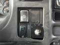 Dashboard controls of a 2006 GMC C5000 featuring various buttons and a rotating switch with numbers from 0 to 3