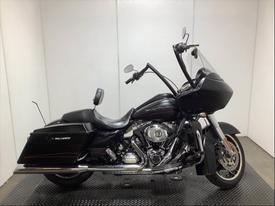 A 2013 Harley-Davidson FLTRX motorcycle with a sleek black body silver engine and prominent windshield showcasing its touring design and character