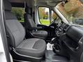 Interior of a 2016 RAM Promaster showing two gray fabric swivel seats with armrests and a dashboard featuring controls and cup holders