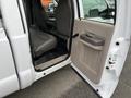 Interior view of a 2010 Ford F-250 SD showing the driver's side door open with gray seats and a beige door panel