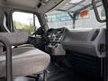 Interior view of a 2012 Freightliner M2 106 showing the driver's seat dashboard and controls with a gray fabric seat and a modern design