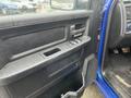 A close-up view of the driver's side door panel of a 2019 RAM 1500 Classic featuring window controls and a storage pocket