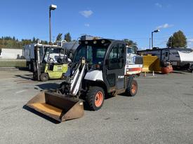 A 2015 Bobcat 5600 with a front loader attachment parked on a lot with other machinery in the background