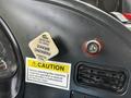 Close-up of the dashboard of a 2012 Autocar Xpert showing a parking brake lever a caution sign and an ignition switch
