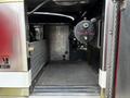 Interior of a 2002 Sutphen Monarch showing empty space with a textured floor and a cylindrical tank labeled with a date