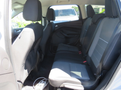 Interior view of a 2015 Ford Escape showcasing the backseat area with two rows of seating in black fabric and a central armrest