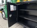 An open storage compartment of a 2015 Freightliner M2 106 with two shelves visible inside