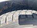 A close-up of a rugged tire from a 2012 Ford F-150 displaying a deep tread pattern designed for traction and off-road capability