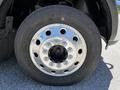 Close-up of a chrome-rimmed wheel with multiple lug nut holes and a tire on a 2015 RAM 5500