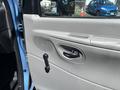 The interior door panel of a 2008 Ford E-350 featuring a rectangular speaker grille a door handle and a manual window crank