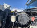 A close-up view of the engine compartment of a 2014 International 7400 showing various engine components including a coolant reservoir and an oil filter
