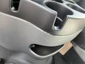 A close-up of the cupholder area in a 2008 Ford Econoline showing a gray plastic design with multiple openings for cups