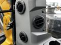 Interior view of a 2024 Caterpillar 306 control panel showing air vents and adjustment knobs