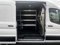 Interior view of a 2020 Ford Transit showing a spacious cargo area with metal shelving and black flooring