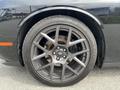 A close-up of a 2017 Dodge Challenger's stylish alloy wheel with a five-spoke design and a low-profile tire mounted on it