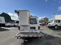 A white 2008 Ford Econoline with a bucket lift mounted on the back parked in a lot