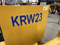A yellow panel of a 2024 AGT Industrial KRW23 Mini Loader with blue lettering displaying the model number KRW23