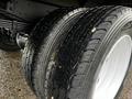 Close-up of two tires from a 2006 Hino 155 showing detailed tread patterns and shiny white rims