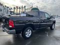 A black 2015 RAM 1500 pickup truck viewed from the rear with visible branding on the tailgate and large tires