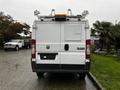 A white 2018 RAM Promaster van viewed from the rear featuring a roof rack and various equipment mounted on top