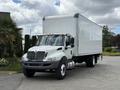 A 2022 International MV607 box truck with a white cargo area and a gray cab parked with its front angled towards the viewer