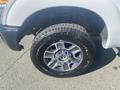 Right front wheel of a 2014 Ford F-250 SD featuring a silver alloy rim and a rugged tire design